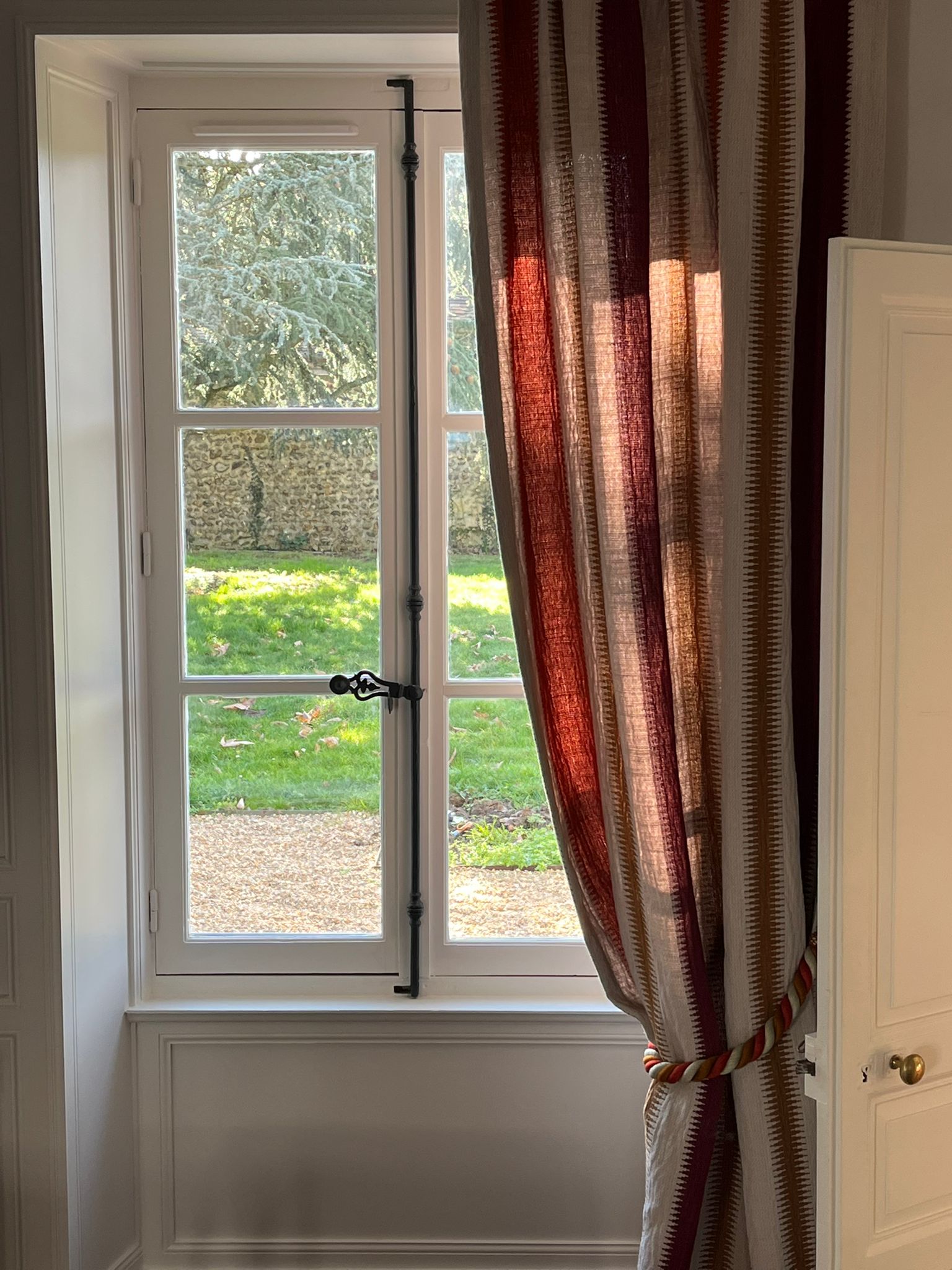 Fenêtre rideau bordeaux vue jardin